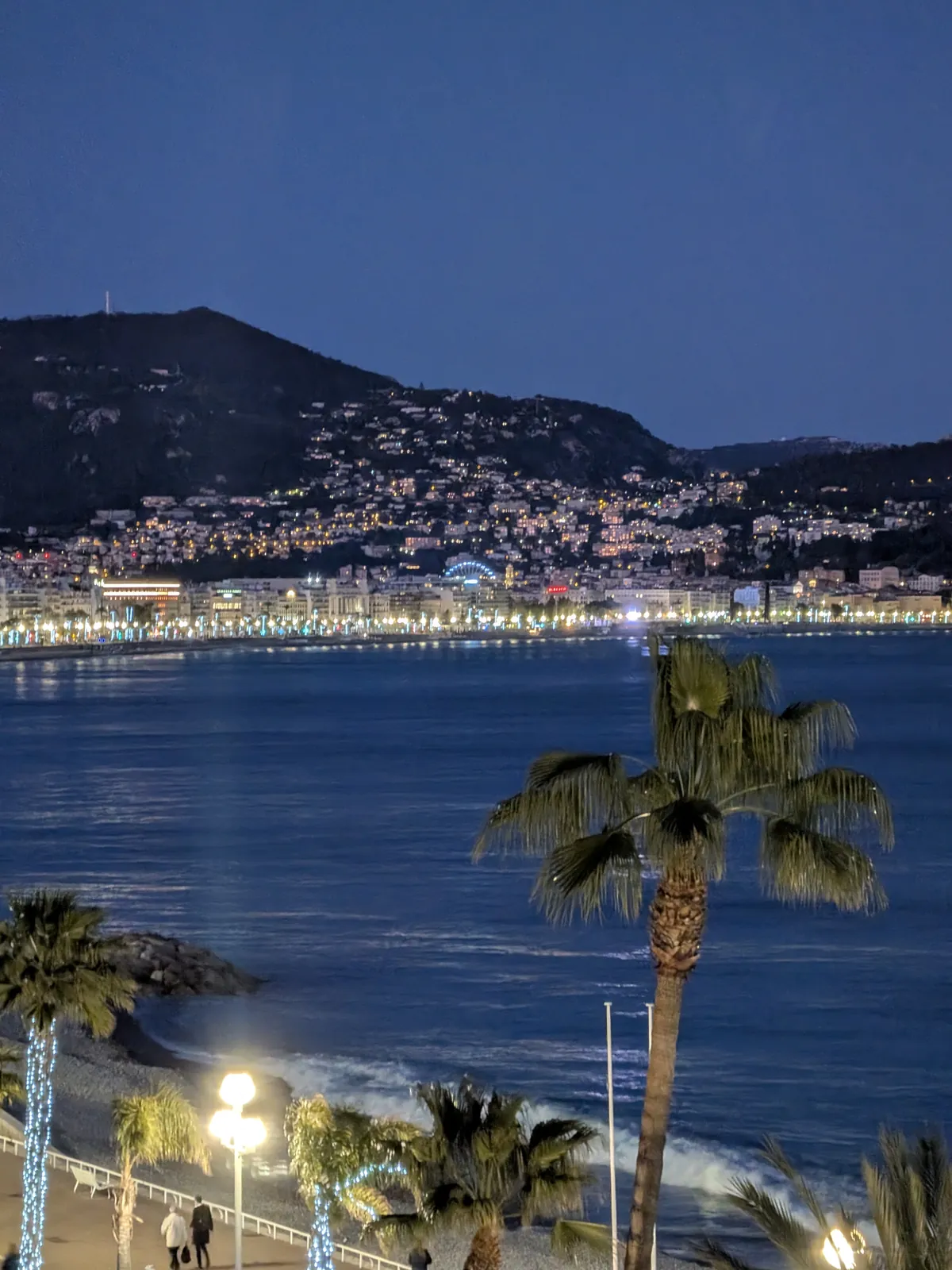 View of the Bay of Nice at night from a balcony